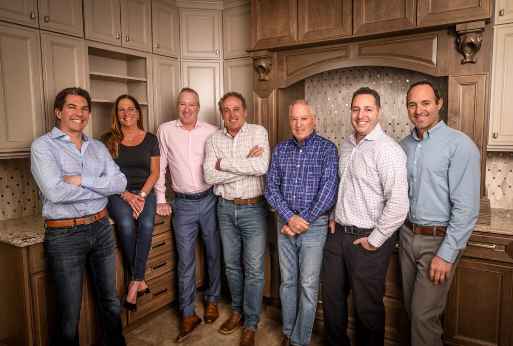 The Shaheen Family, dressed nicely, smiling, standing in front of a new kitchen display